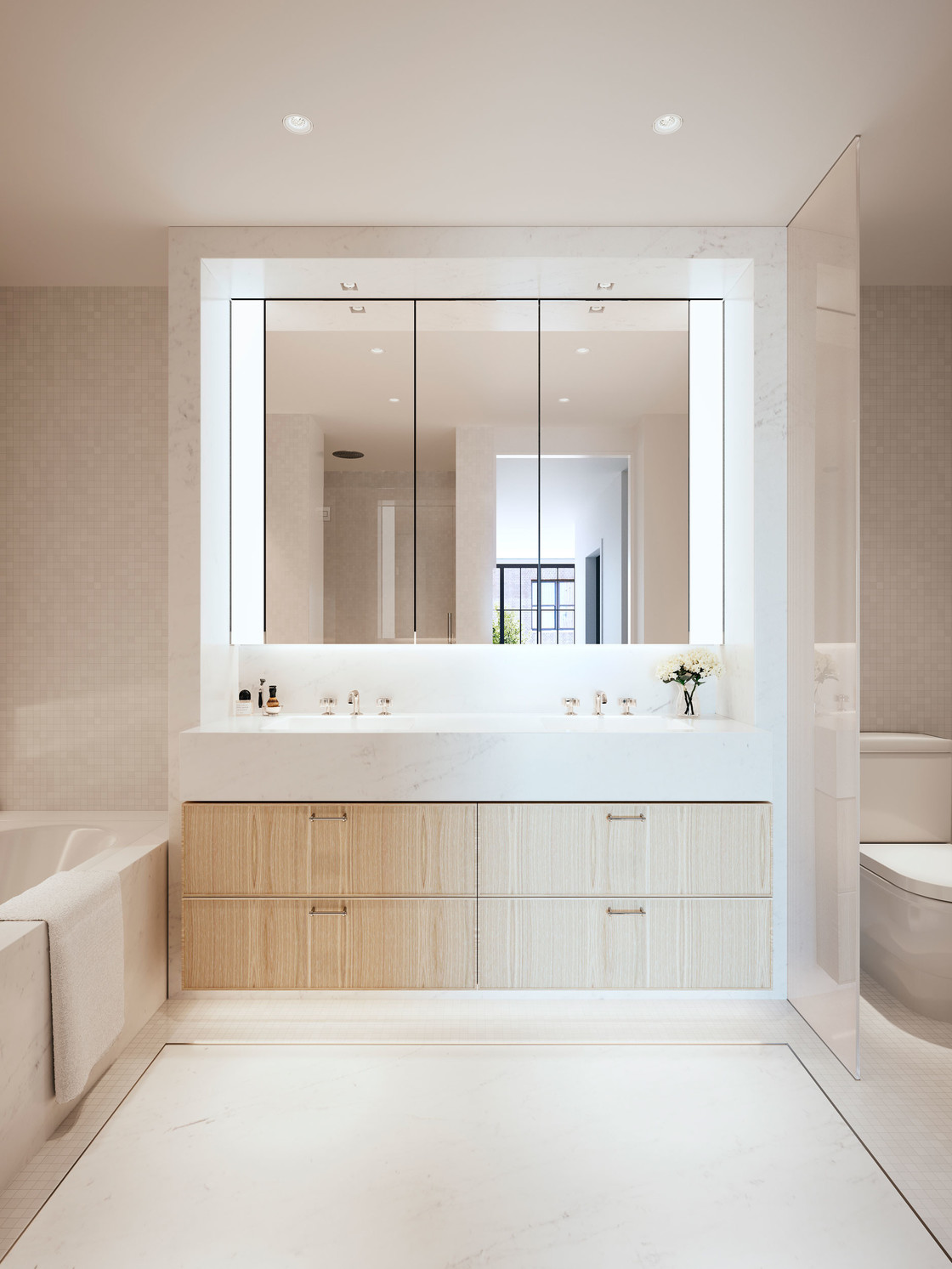 The master bathroom has a sense of classic, clean simplicity created with rich finishes and detail. A fresh, bright palette of slab Andromeda white marble and mosaic is complemented by elements of warm oak wood cabinetry. A rain shower, deep soaking tub, and heated floors infuse the everyday with an air of luxury.